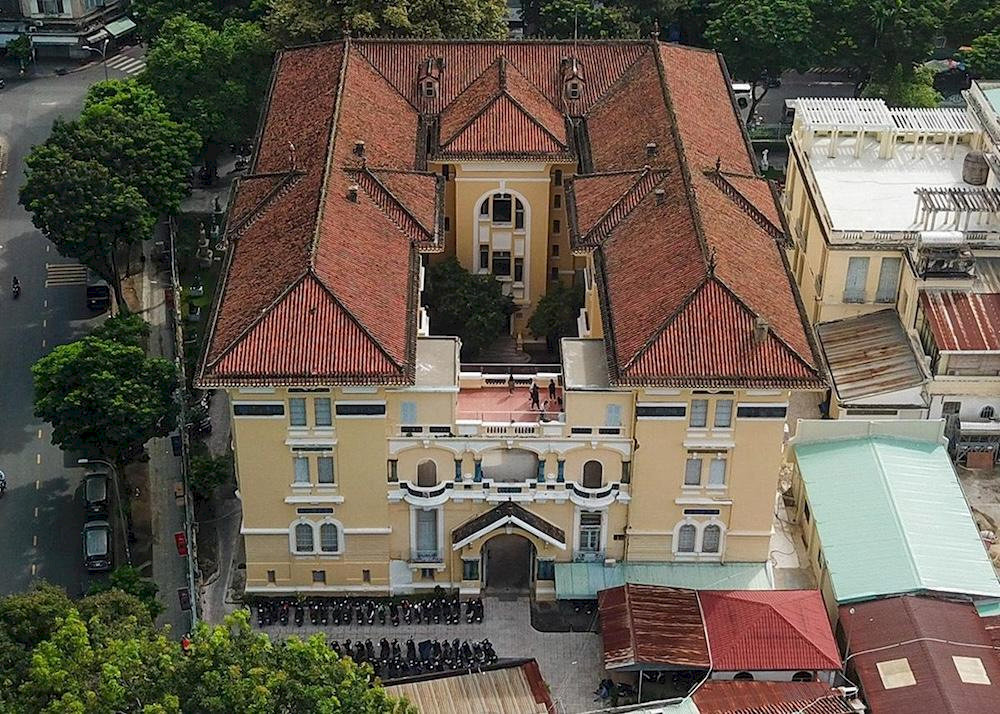 The Art Deco building blends Asian traditions with Western modernity, featuring a red yin-yang tiled roof symbolic of Vietnamese architecture